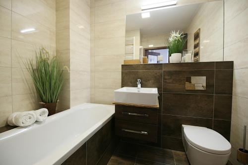 y baño con bañera, aseo y lavamanos. en Apartimento Naturale, en Wroclaw