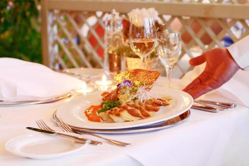 a table with a plate of food and a glass of wine at Landhaus Wacker in Wenden