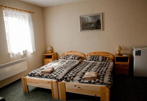 una camera da letto con due letti singoli e una finestra di Berger Pince-vendégház, Hajósi pincék a Hajósi Pincék