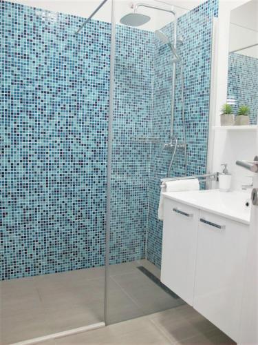 a bathroom with a glass shower and a sink at SeaEye Trogir in Trogir