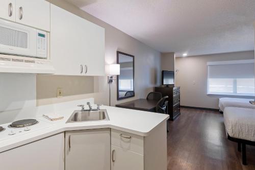 uma cozinha com um lavatório e uma sala de estar em Extended Stay America Suites - Charlotte - Pineville - Park Rd em Charlotte