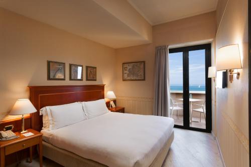 A bed or beds in a room at Hotel Imperiale Rimini & SPA