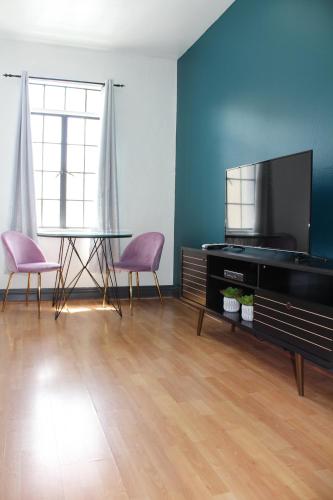 a living room with a tv and a table and chairs at Libra Hotel in Los Angeles
