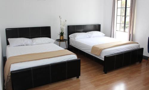 two beds sitting next to each other in a room at Libra Hotel in Los Angeles