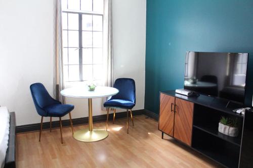 een kamer met een tafel en twee stoelen en een televisie bij Libra Hotel in Los Angeles