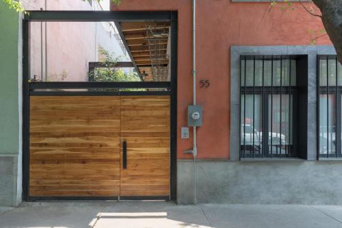 una puerta de madera en el lateral de un edificio en 55 Fernández Leal, en Ciudad de México