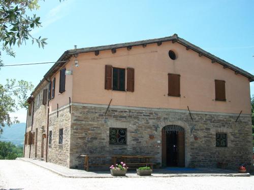 an old stone building with windows on a street at Agriturismo La Caputa in Urbania