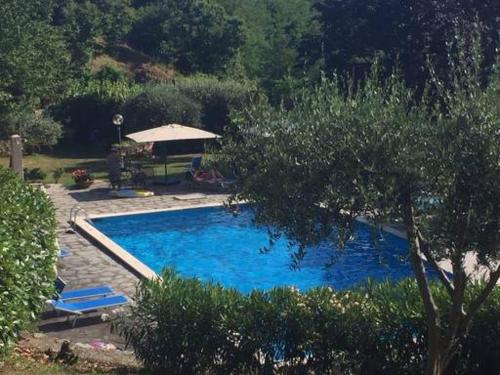 a large blue swimming pool with a gazebo at la casa del pittore Anna house in Lerici