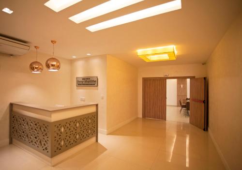 an office lobby with a reception desk and lights at Paradiso Macae Hotel in Macaé