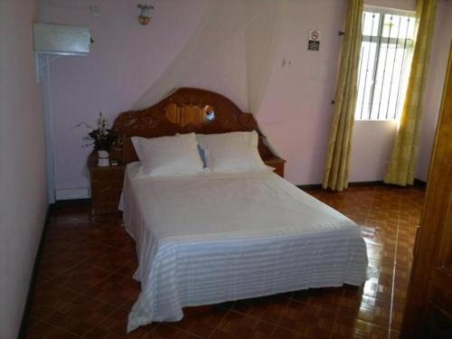 um quarto com uma grande cama branca num quarto em La villa de christiane em Grand Baie