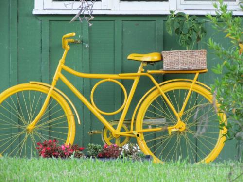 ein gelbes Fahrrad, das neben einer grünen Wand parkt in der Unterkunft Pousada Longe Vista in Tibagi