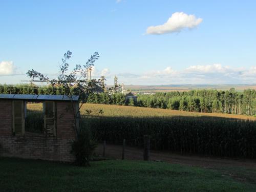 a house in front of a field of crops at Pousada Longe Vista in Tibagi