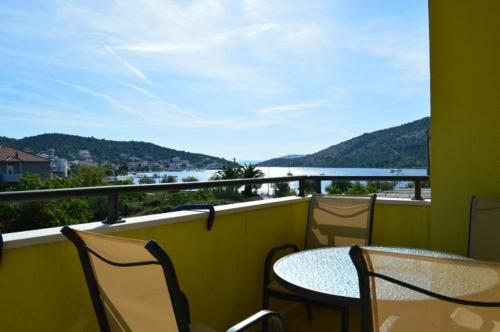 a balcony with tables and chairs and a view of the water at Apartmani Marino in Vinišće