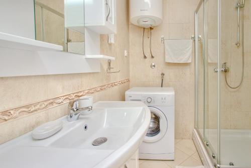 a bathroom with a sink and a washing machine at Sea Star Luxury Apartment in Kotor