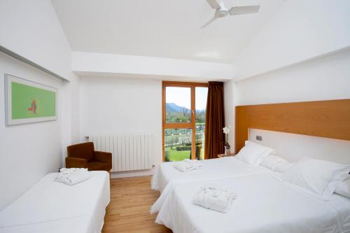 a hotel room with two beds and a window at Tierra de Biescas in Biescas