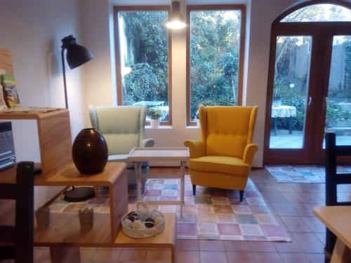 uma sala de estar com duas cadeiras e uma mesa em Fiorita Vendégház em Eger