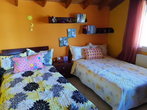 2 łóżka w pokoju z żółtymi ścianami w obiekcie Dimitra's home w Salonikach