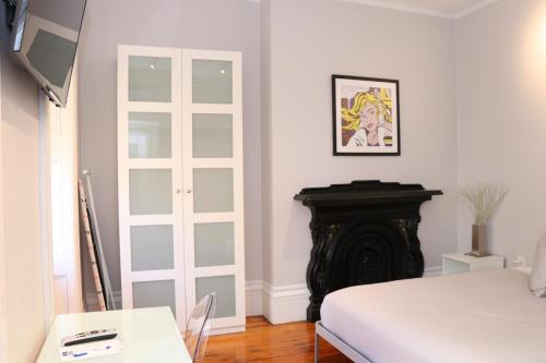 Habitación blanca con cama y chimenea en Downtown Beacon Hill, Convenient, Comfy Studio #10, en Boston