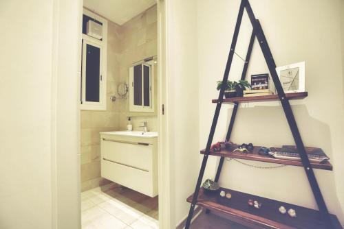 バルセロナにあるDip2の洗面台の横に棚付きのバスルーム