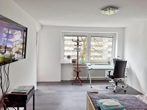 a white living room with a desk and a chair at apartment near underground station in Munich