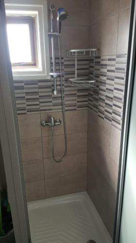a shower in a bathroom with a glass door at Manoli Apartments in Ayia Napa