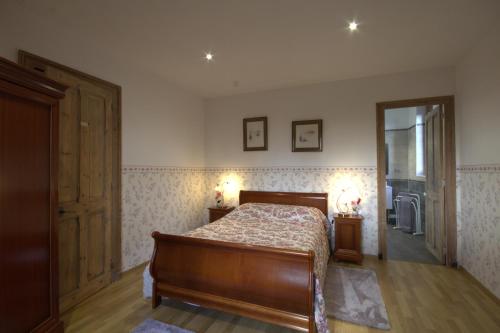 1 dormitorio con cama y espejo. en Petit Manoir du Bosc, en La Neuville-du-Bosc