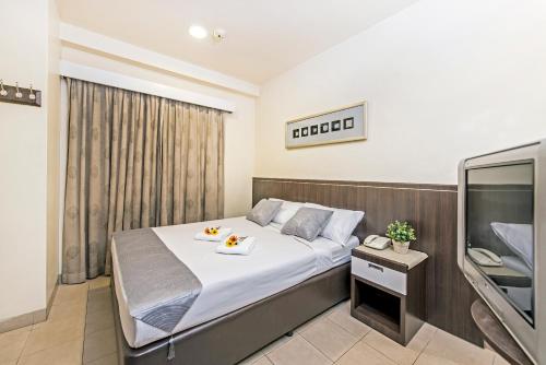 Habitación de hotel con cama y TV en Hotel 81 Balestier en Singapur