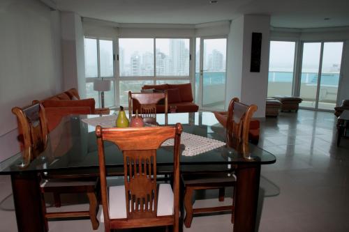 comedor con mesa de cristal y sillas en Apartamento semi penhouse en Cartagena de Indias