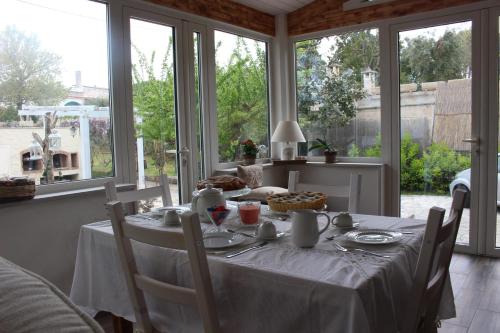 セルヴァ・ディ・ファザーノにあるB&Bcasamalìの窓のある部屋で、テーブル(白いテーブルクロス付)