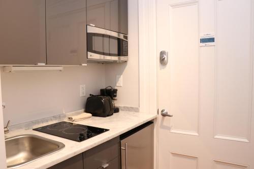 eine Küche mit einer Spüle und einer Mikrowelle in der Unterkunft Charming & Stylish Studio on Beacon Hill #11 in Boston
