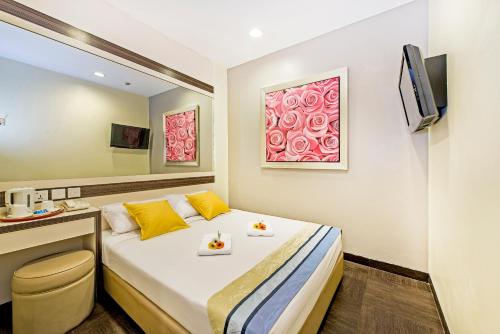 ein Hotelzimmer mit einem Bett und einem TV in der Unterkunft Hotel 81 Bugis in Singapur
