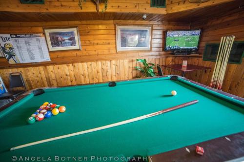 a green pool table in a room with a wall at St. Croix Inn in Solon Springs