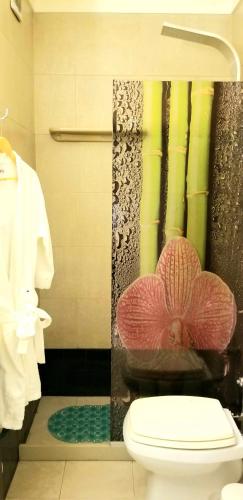 ein Badezimmer mit Toilette und einer Blume an der Wand in der Unterkunft Studio Harrods in Buenos Aires