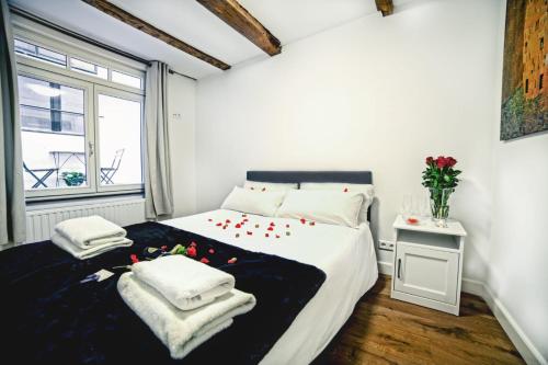 1 dormitorio con 1 cama grande con sábanas blancas y ventana en Beautiful DutchHouse Centrum, en Ámsterdam