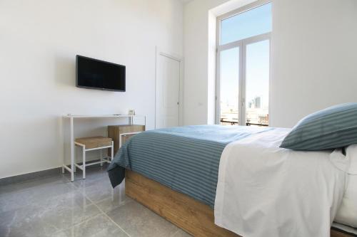 a bedroom with a bed and a desk and a television at City View Naples in Naples
