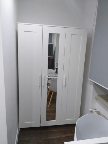a bathroom with white cabinets and a mirror at Studio Fibra Doppio in Rybnik