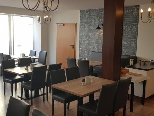 a restaurant with tables and chairs in a room at Pension Am Ozeaneum in Stralsund
