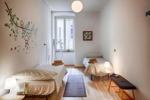 Cette chambre comprend 2 lits et une table. dans l'établissement TriesteHost - Via Torino, à Trieste