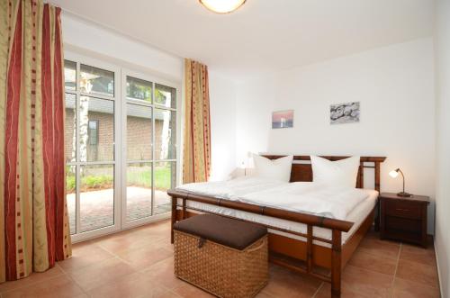 a bedroom with a bed and a large window at Lottis Utkiek in Middelhagen