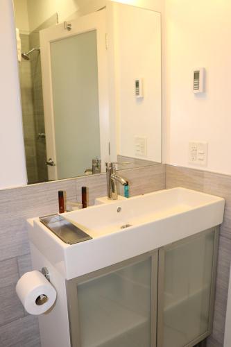 La salle de bains est pourvue d'un lavabo blanc et d'un miroir. dans l'établissement Downtown Beacon Hill, Convenient, Comfy Studio #14, à Boston