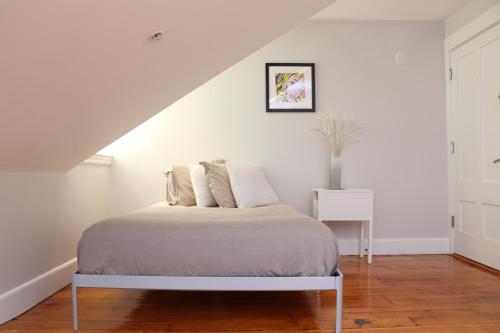 a white bedroom with a bed and a staircase at Downtown Beacon Hill, Convenient, Comfy Studio #14 in Boston