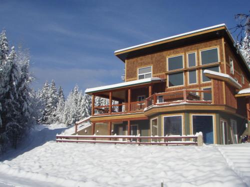 a large wooden house in the snow at Cedar House Restaurant & Chalets in Golden