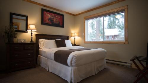 a bedroom with a large bed and a window at Cedar House Restaurant & Chalets in Golden