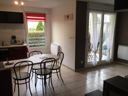 une salle à manger avec une table et des chaises et une cuisine dans l'établissement L Édelweiss et sa piscine, à Albertville