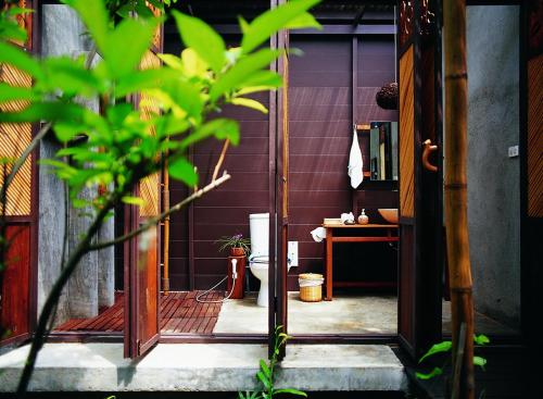 an open door of a room with a desk and a table at Proud Phu Fah Maerim Resort in Mae Rim