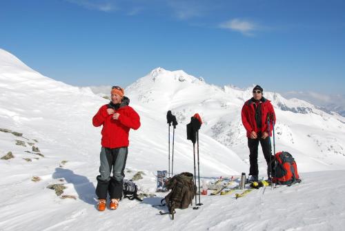 two men standing on top of a snow covered mountain at Pension Rosenhof in Brixen im Thale