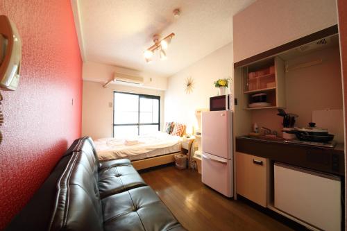 mały pokój z kanapą i łóżkiem w obiekcie Exsaison Shirokita 101 w Osace