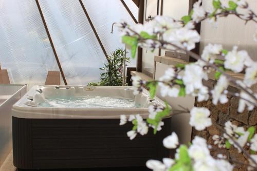 a jacuzzi tub in a room with white flowers at Turismo Homes Solar Do Areal in Braga