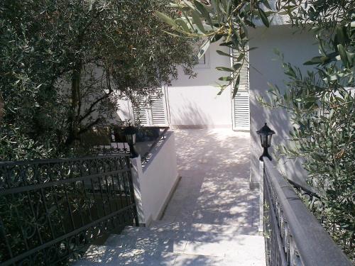 a stairway leading up to a white building with a fence at Oaza Guest House in Sveti Stefan
