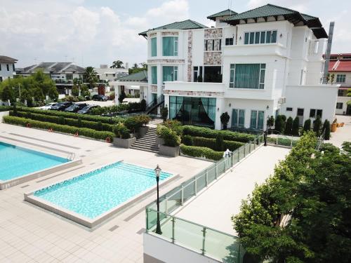 a large white building with a swimming pool at Casa Bianca in Kluang